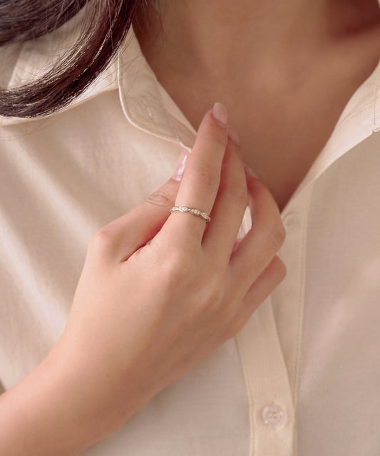 Milgrain marquise eternity band worn on the index finger, hand resting at a shirt collar